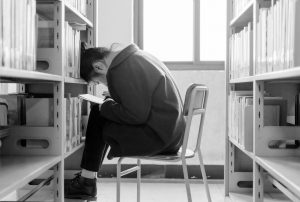 Stress im Studium _ Mädchen in einer Bibliothek