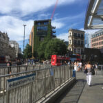 Bildausschnitt mit Blick auf Gebäude mit Straßenzügen in London. Im Vordergrund ein Abgang zur U-Bahn.